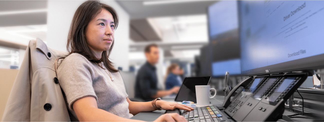 Focused Viking team member working at a desk with multiple monitors in an office setting.